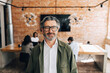 © Maskot - Portrait of smiling senior businessman wearing eyeglasses at office