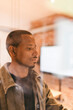 © Maskot - Thoughtful businessman looking away seen through glass in office