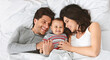 © Prostock-studio - Family spending free time at home. Cheerful parents having fun with their baby boy in bed, top view, panorama