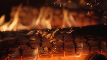 Sticker - a macro shot captures delicate sparks jumping from a slowly burning log, in shallow depth of field c