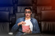 © Prostock-studio - Alone in the movies. Young guy with shocked look on his face in film theater