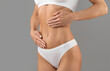 © Prostock-studio - Cropped Shot Of Young Female In White Underwear Touching Belly With Two Hands, Unrecognizable Woman With Slim Sporty Body Posing Isolated Over Grey Studio Background, Closeup, Copy Space