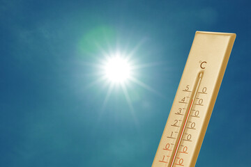 Wall Mural - thermometer showing high temperature against sky with bright sun. extremely hot weather