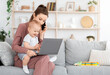 © Prostock-studio - Balancing Work And Motherhood. Young mom holding baby while talking on phone and working on laptop at home, free space