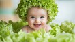 © Von - A baby wearing a hat made of lettuce, sitting in a pile of lettuce leaves. The baby is smiling and appears to be happy.