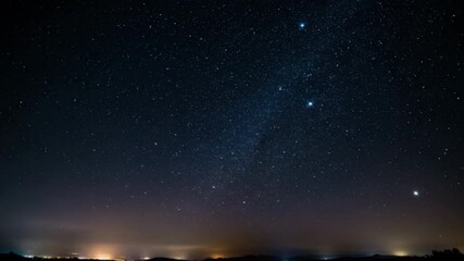 Wall Mural - Distant stars become visible and travel across the night sky as a subtle city glow illuminates the distant horizon overhead, timelapse, exploration