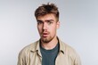 © bodnarphoto - Young man with surprised expression against a plain background.