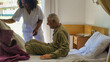 © jovannig - Young african female doctor helping elderly retired man in the hospital bed