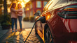 © kora studio - Electric vehicle charging in urban setting with two women in background. warm sunlight creates vibrant , highlighting modern design of car