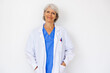 © Xavier Lorenzo - Portrait of happy senior female doctor looking at camera over white background at medical consultation in hospital