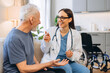 © Maria Vitkovska - Doctor visiting senior man at home discussing healthcare