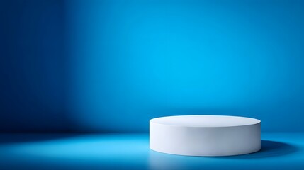 Wall Mural - A clean white cylindrical podium stands on a smooth gradient blue surface under bright studio lighting