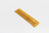 A handcrafted wooden comb with smooth finish and natural grain isolated - on white background. Designed for gentle hair grooming. 