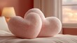 © saha - Soft pink heart shaped pillows rest gently on bed, creating cozy and romantic atmosphere in warmly lit bedroom. plush texture adds touch of comfort and elegance