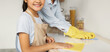 © Prostock-studio - Young asian mother teaching her daughter housekeeping, cleaning kitchen together and smiling at camera, selective focus. Cute girl wiping table with cloth, enjoying helping with household chores