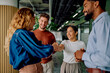 © we.bond.creations - Diverse business people shaking hands, smiling at a successful agreement during a meeting in a modern office environment