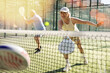 © JackF - Mature sporty woman playing padel game in court on sunny day