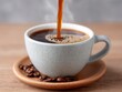 © senda - Close Up of Coffee Pouring into Ceramic Mug on Wooden Saucer with Coffee Beans