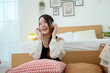 © tonefotografia - Young Asian woman wearing headphones enjoying music in bedroom at home