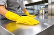 © artbot - Person cleaning stainless steel counter in a kitchen