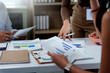 © amnaj - Business team analyzing financial data charts in office meeting