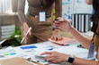 © amnaj - Businesswomen discussing data analysis during office meeting