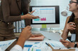 © amnaj - Businesswomen analyzing data during financial team meeting