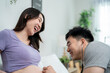 © Kawee - Asian expectant couple sharing loving moment, ready to become parents.
