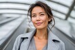 © Lubos Chlubny - Professional asian woman smiling on an escalator commuting
