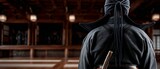Person in traditional martial arts uniform, wooden dojo background
