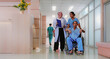 © Nassorn - Health care doctor and nurse walking together with patient on wheelchair. Medical staff hospital team discuss medicine or clinic insurance planning. Diverse people healthcare workers collaboration.