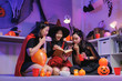 © crizzystudio - Young women enjoying halloween costume party reading book