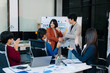 © NINENII - Startup asian business team collaborating in modern office, reviewing project strategy, sharing ideas, and building success through teamwork and planning.