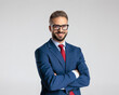 © Viorel Sima - happy elegant man with glasses in navy blue suit crossing arms and smiling