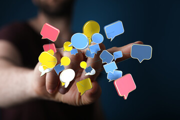Man's hand reaching toward a network of speech bubbles, symbolizing online conversations, social media, and digital interactions. Perfect for te
