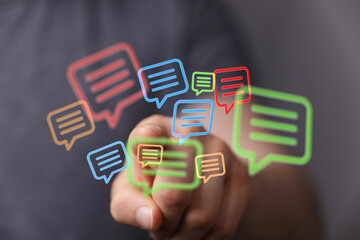 A hand touching message bubbles, representing social network communication and feedback, ideal for technology and connection concepts.