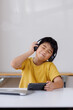 © Phimwilai - Asian boy enjoying music with headphones and smartphone at home