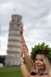 University graduate under the Leaning Tower in Pisa with laurel crown striking iconic pose