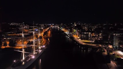 Wall Mural - Aerial view flying along the Aura river, night in illuminated Turku city, Finland