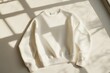 © dashtik - Minimalist white sweatshirt on bright background with natural shadows and dry grass decor
