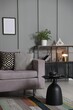 © New Africa - Soft sofa, side table and shelving unit near grey wall in living room. Interior design