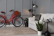 © New Africa - Red bicycle, lamp and cozy sofa near grey wall indoors