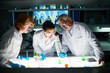 © pressmaster - Group of ambitious microbiologists studying liquid sample contained in test tube in laboratory. They standing at the table with different objects necessary for conducting experiment