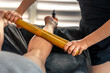 © puhimec - Bamboo stick rolling on calf in bright spa. Lymphatic tone.