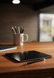 © Maxis Studio - Elements include a sleek black tablet, a black pen, a white mug with black pens, a closed notebook with a white spine, a polished wooden desk surface, warm ambient lighting, and a blurred background