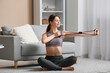© Pixel-Shot - Beautiful young woman training with fitness expander in living room