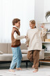 © SHOTPRIME STUDIO - Two children dance together in a bright living room, barefoot and smiling, capturing a moment of pure joy and playful energy as they share a friendly routine.