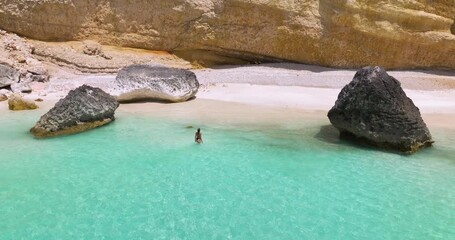 Wall Mural - Woman On A Pristine White-sand Beach With Turquoise Water And Large Rock Formations In Socotra Island, Yemen. - aerial shot