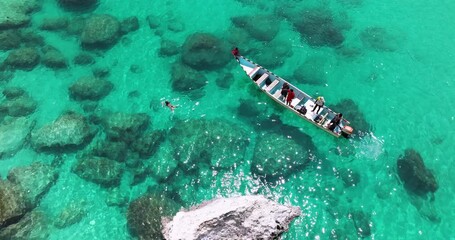 Wall Mural - Aerial View Of Woman Swimming In The Clear Water Next To The Boat In Socotra Island, Yemen.