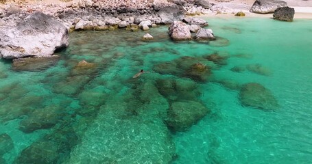 Wall Mural - Woman In Bikini Swimming In The Clear, Turquoise Water Of Shoab Coast In Socotra Island, Yemen. - aerial shot